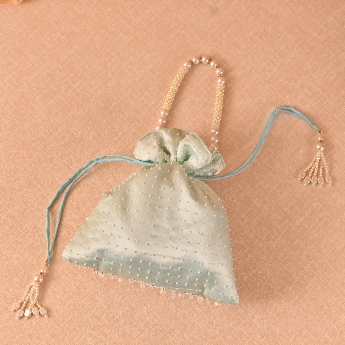 Banaavat Essence Muslin Silk Potli – White Bead & Pearl Embellished (Pastel Blue, Red & Yellow)